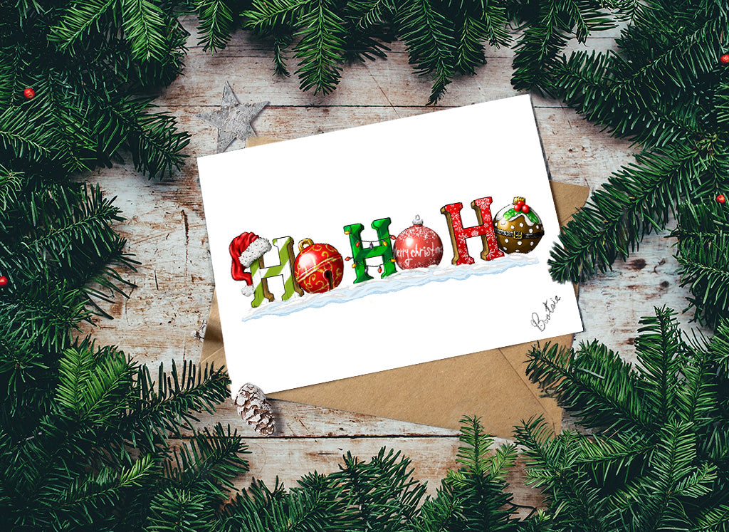 Christmas card with colorful ornaments spelling 'HO HO HO' surrounded by pine branches on a wooden surface.