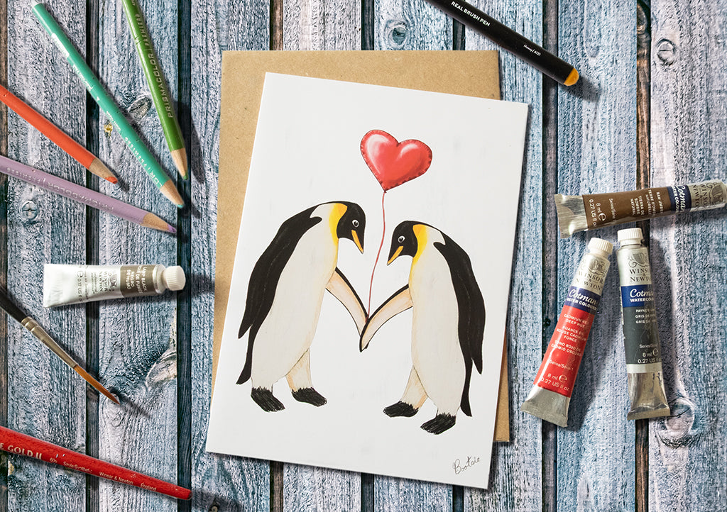 Penguins holding a Heart Balloon Greetings Card 7x5