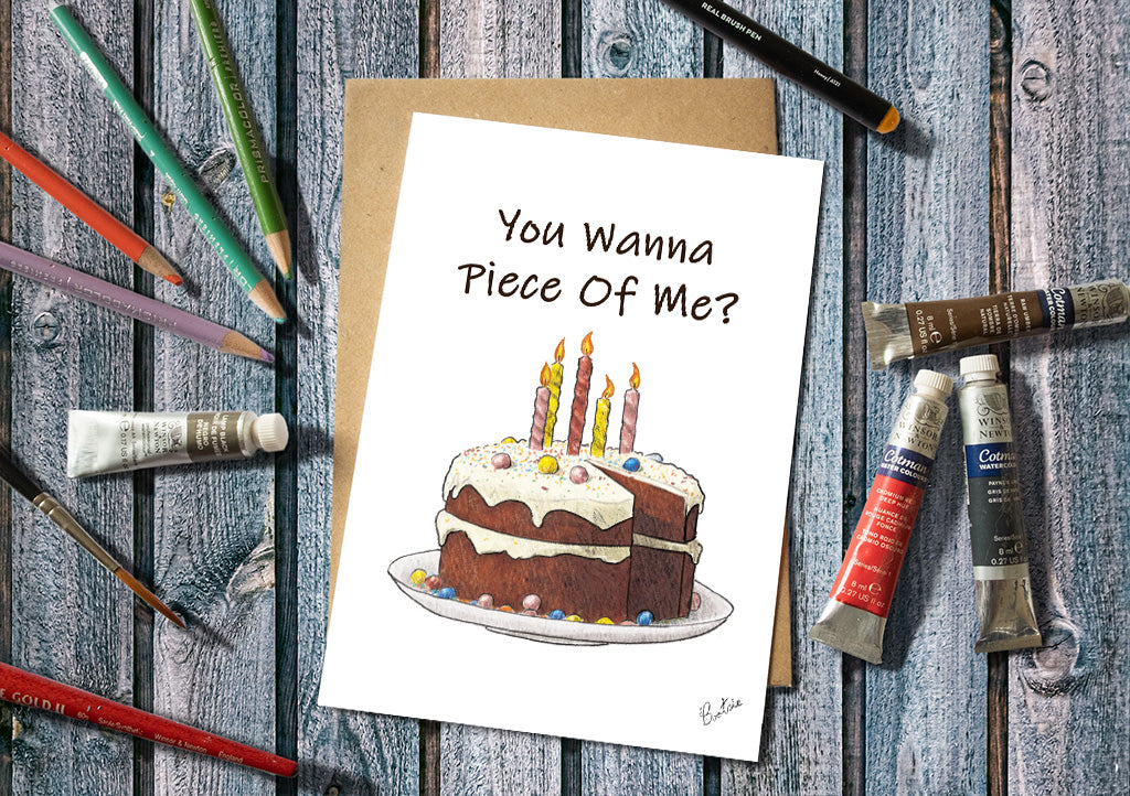 Greeting card with a cake illustration and text on a wooden surface with art supplies.